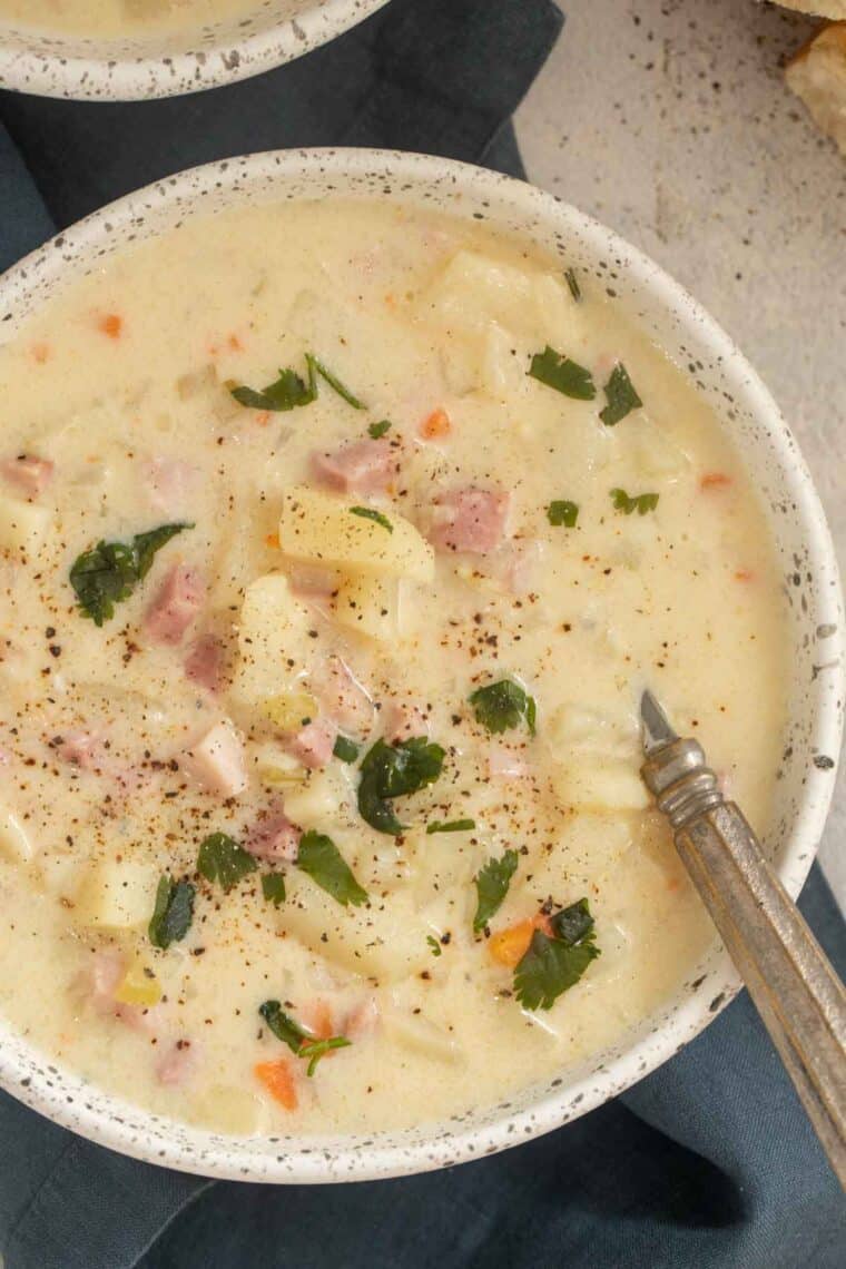 Ham and potato soup recipe in serving bowl with spoon.