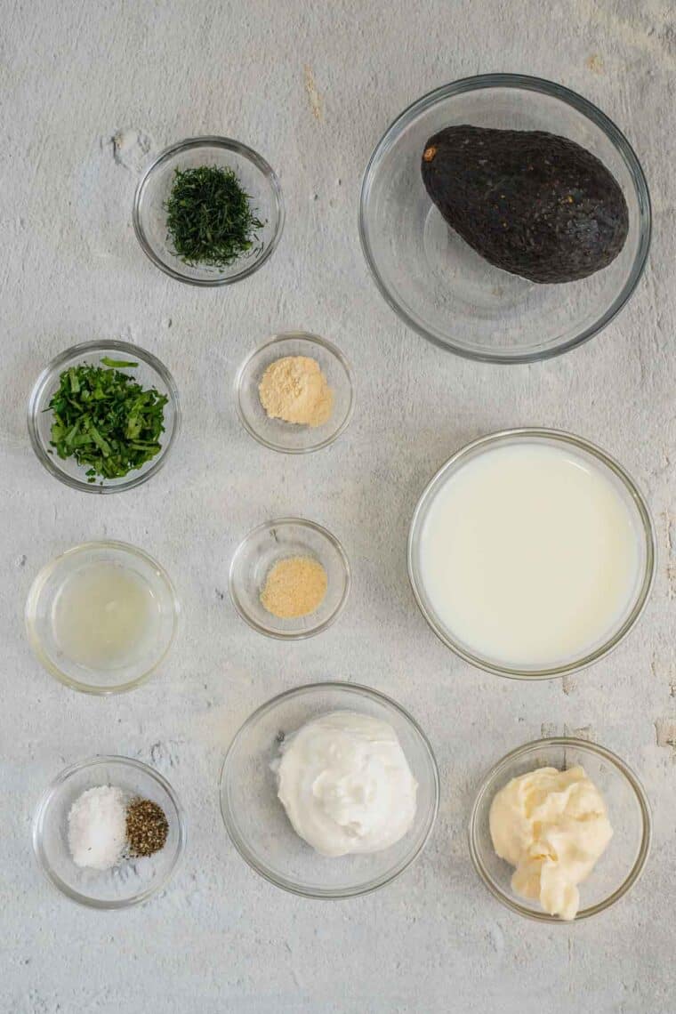 All ingredients needed to make avocado ranch dressing separated in small bowl.