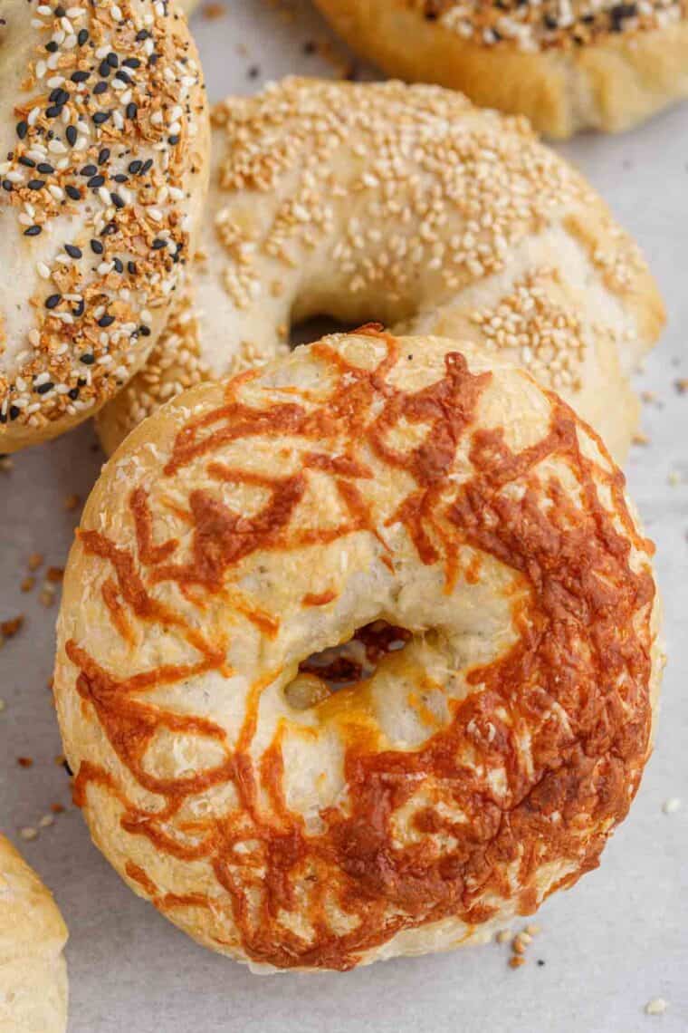 Close up picture of finished bagel topped with melted cheese.
