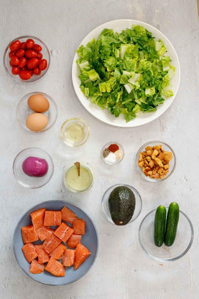 All ingredients separated into bowls that are needed to make salmon salad.