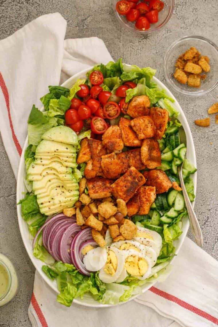 Salmon salad in a serving plate with a side of croutons.