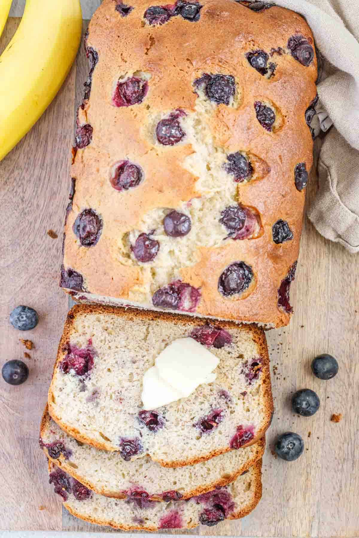 Slices of blueberry banana bread with butter spread.