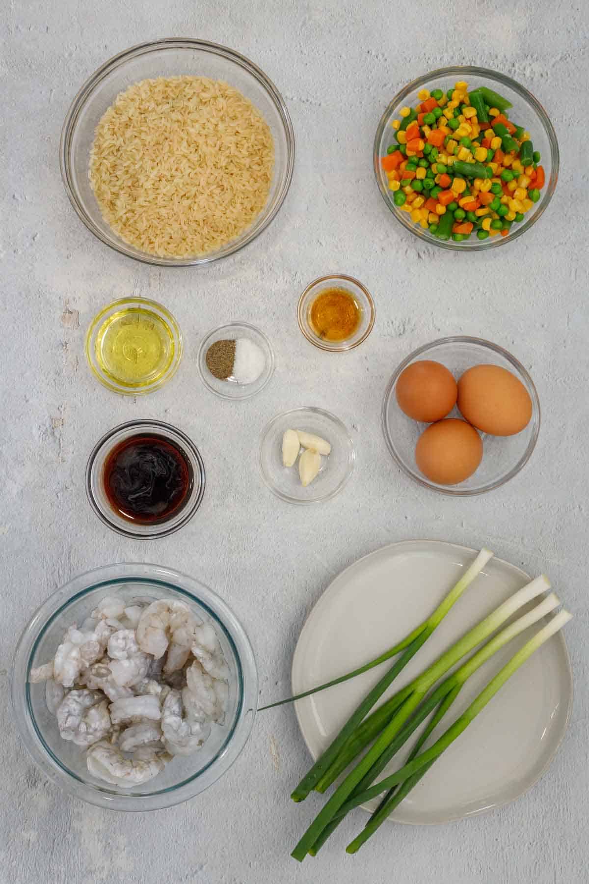 All ingredients needed to make shrimp fried rice separated.