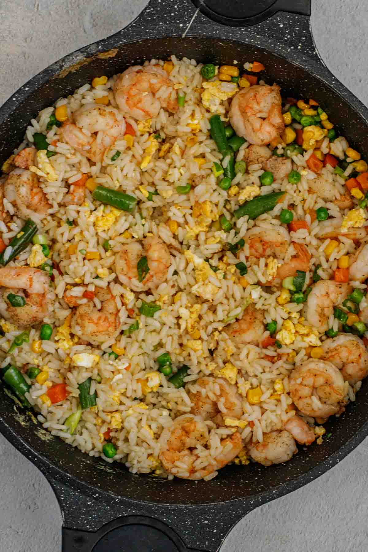 Close up of shrimp fried rice recipe topped with greens.