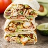 Stacked chicken wraps with avocado on the side.