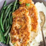 Crusted chicken sided with green beans and mashed potatoes.