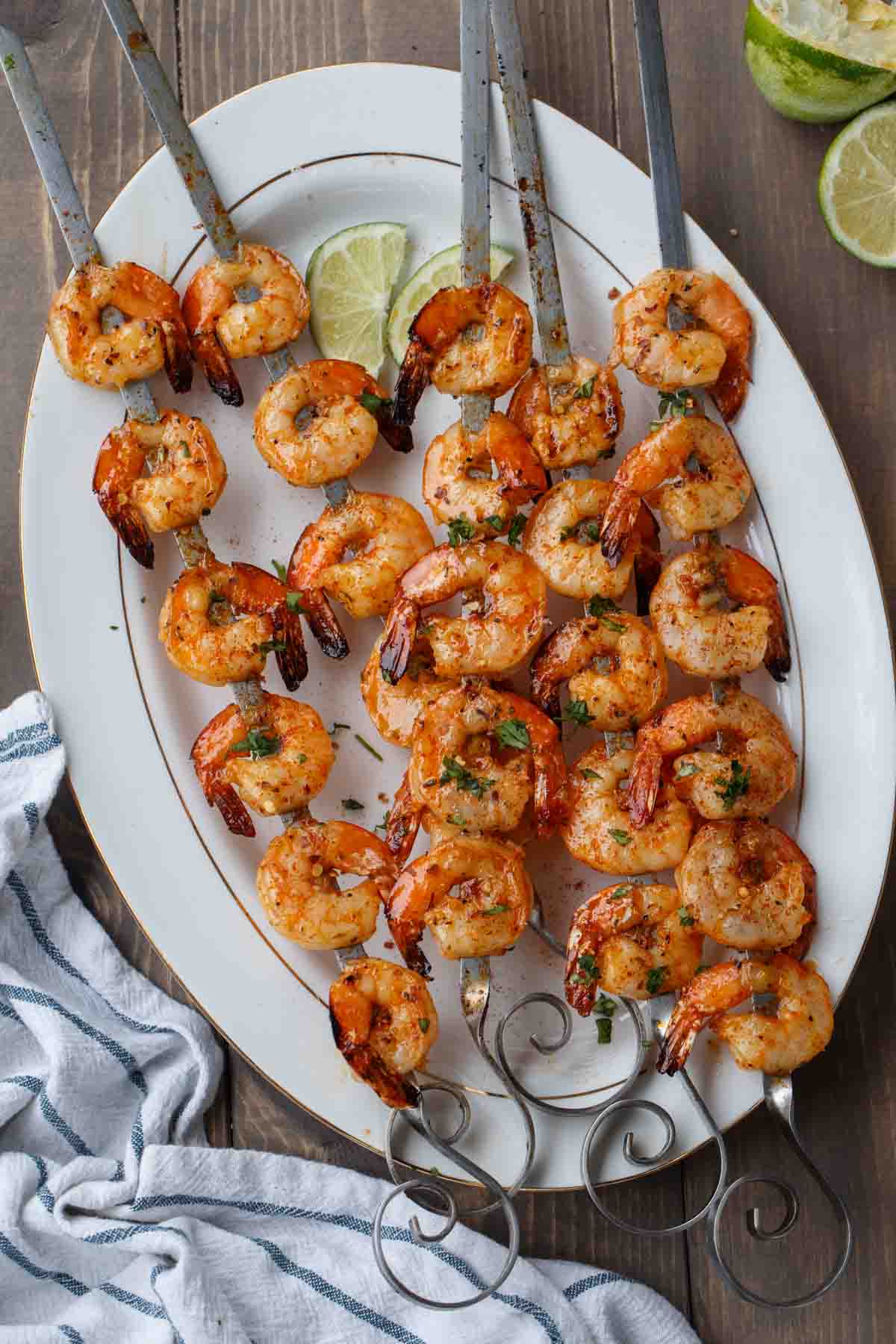 Grilled shrimp on skewers on a platter.