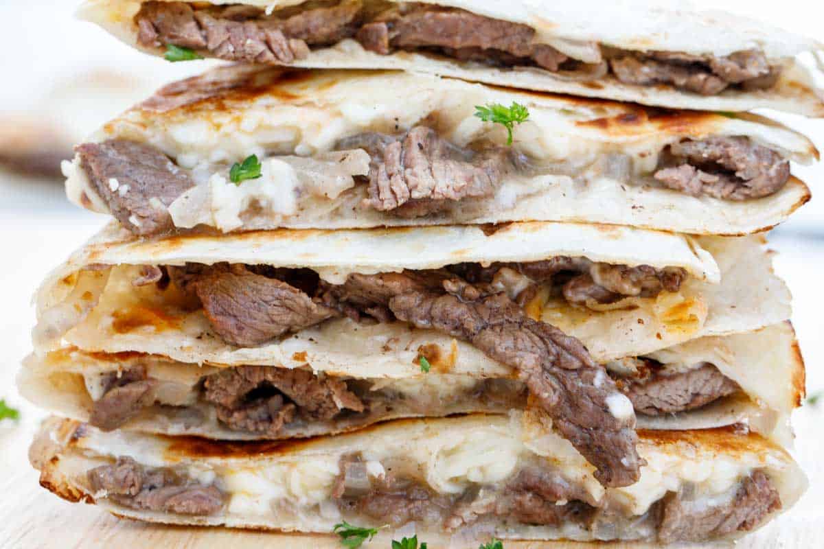 Cheesy steak fajitas stacked on top of each other.