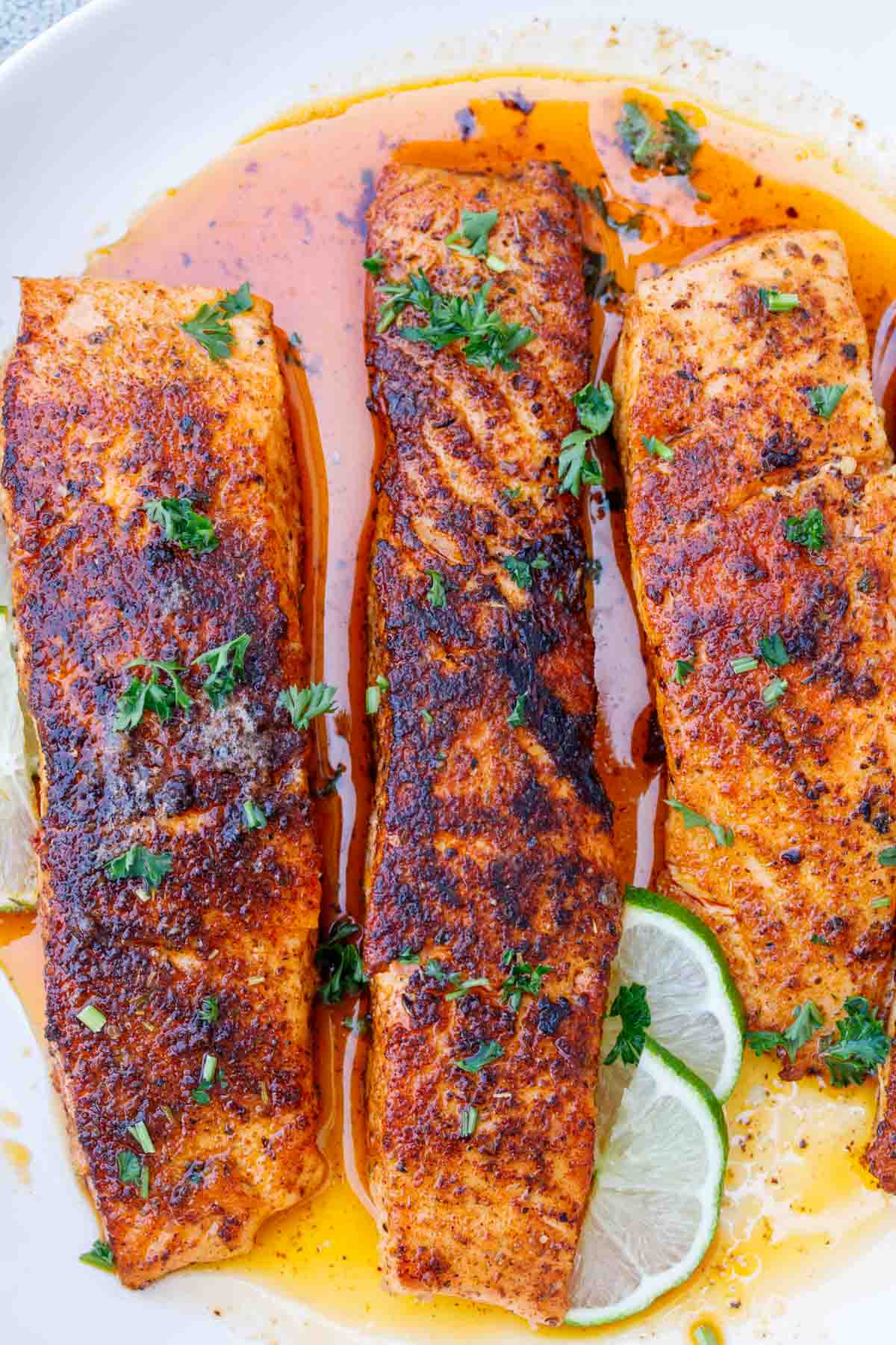 Three salmon fillets on a plate. 