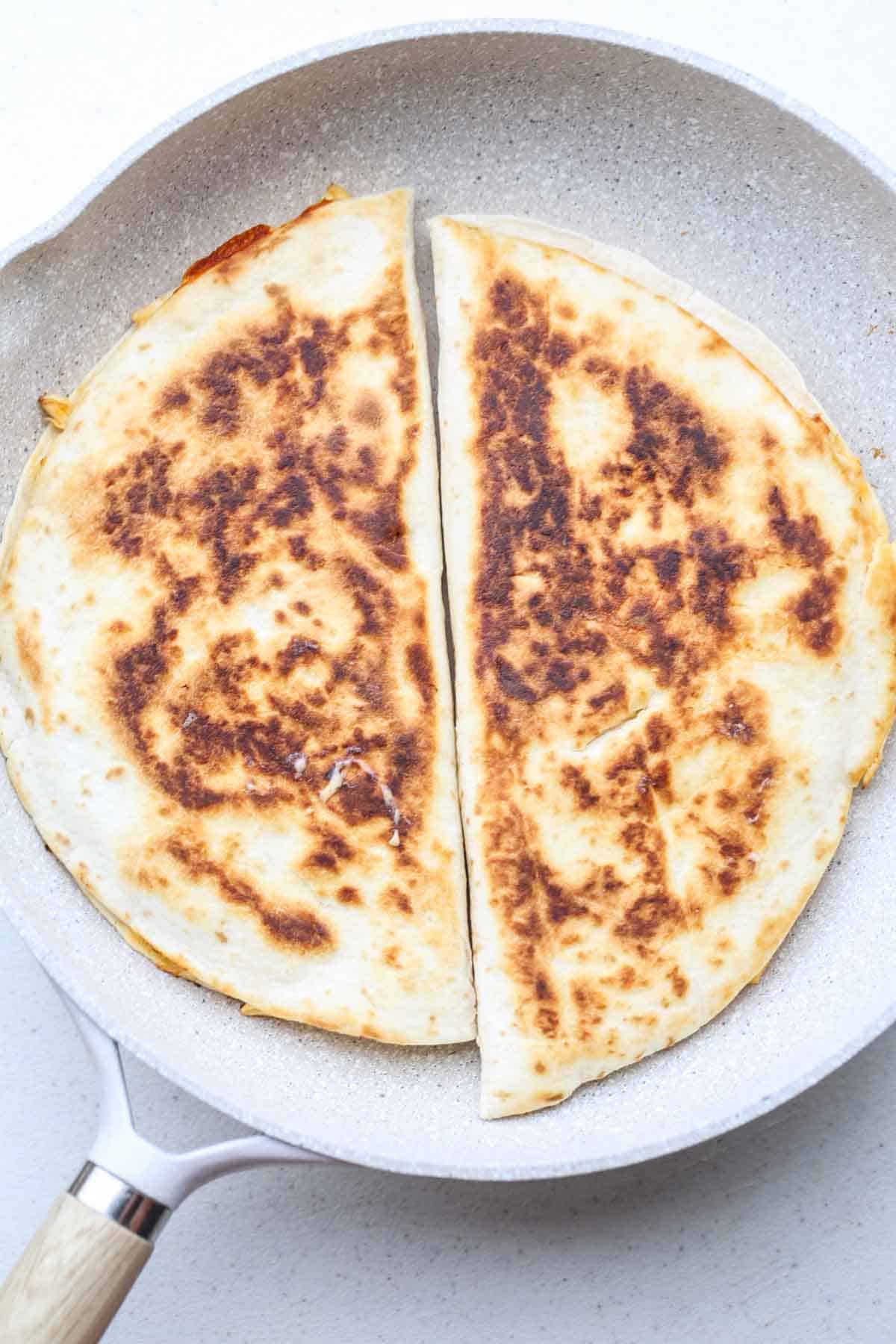 A pan with the cooking quesadillas side by side. 