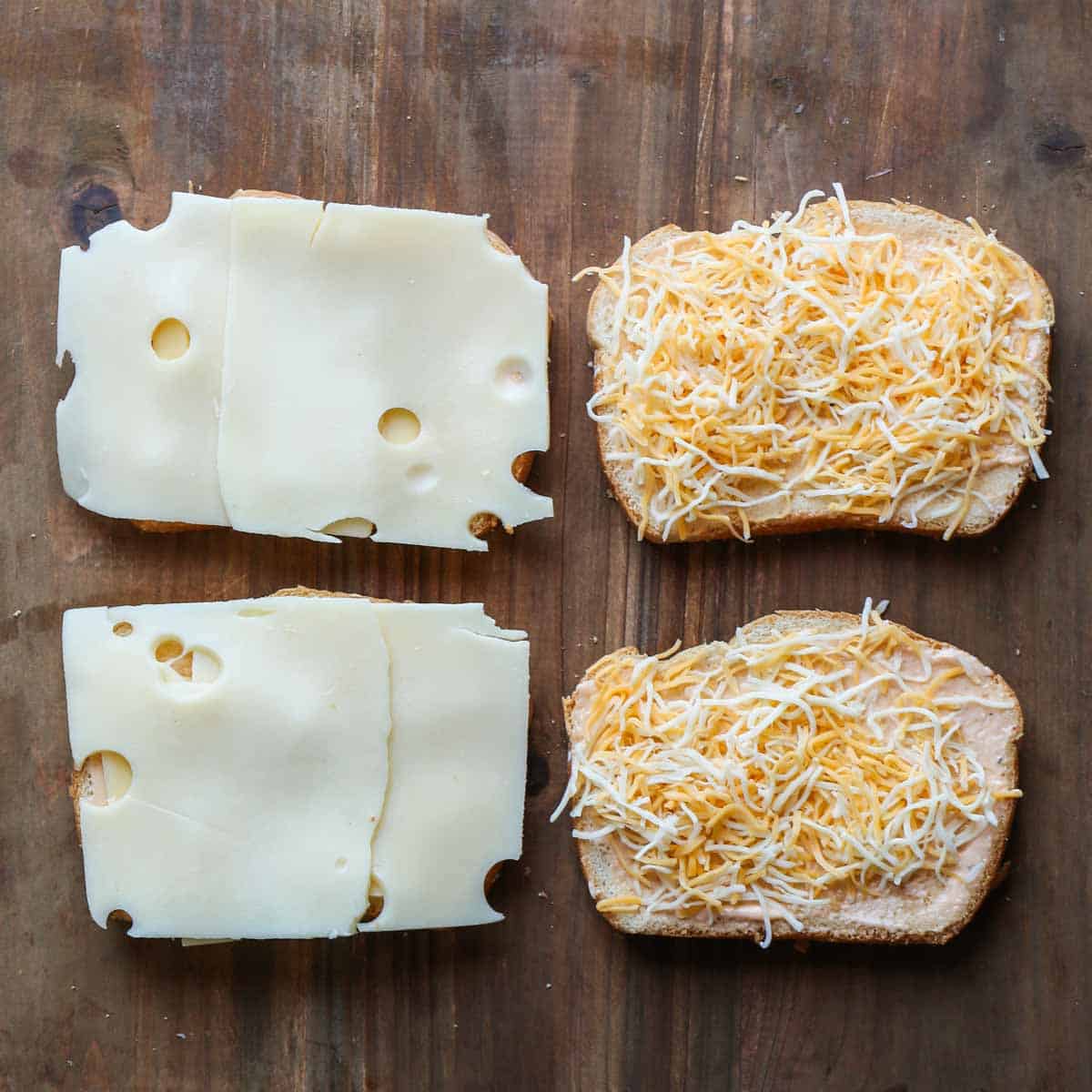 Four slices of bread with the sauce, and cheese, topped with additional shredded cheese. 