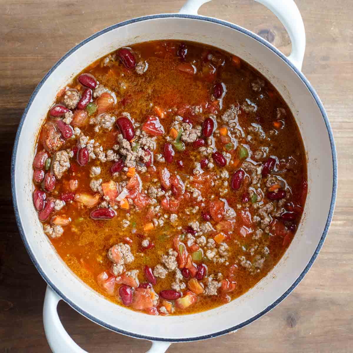 The pot of cooking chili with broth. 