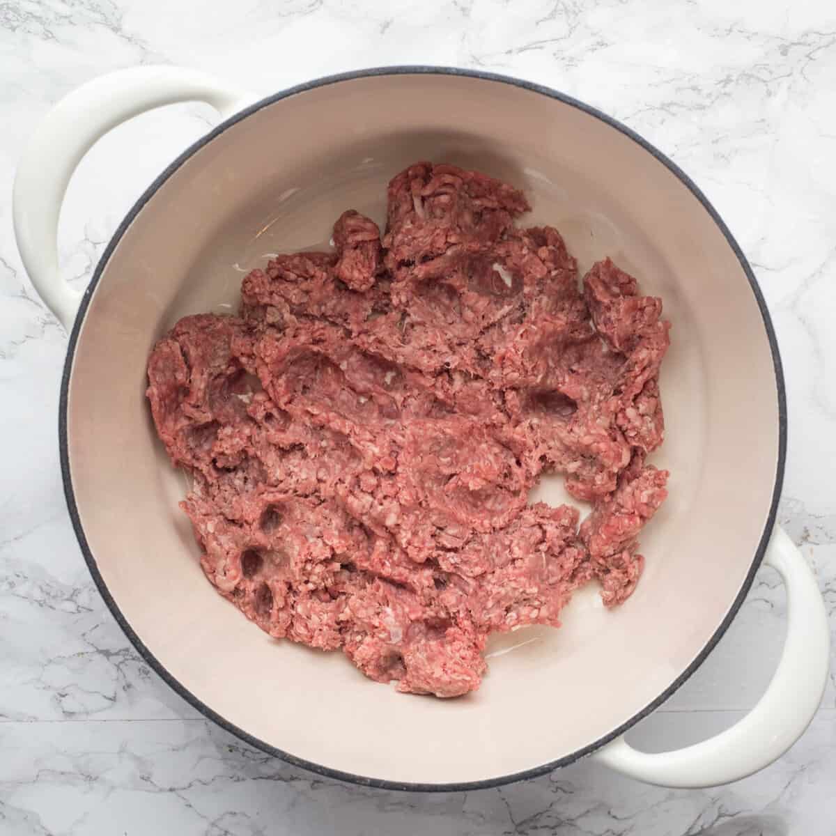 A pot with ground beef cooking inside of it.
