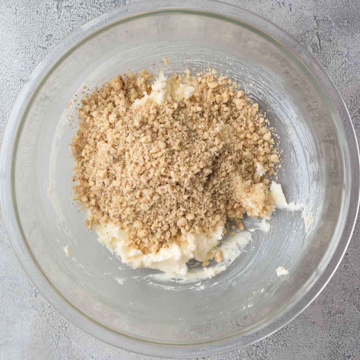 A glass bowl with the combined flour and nuts.