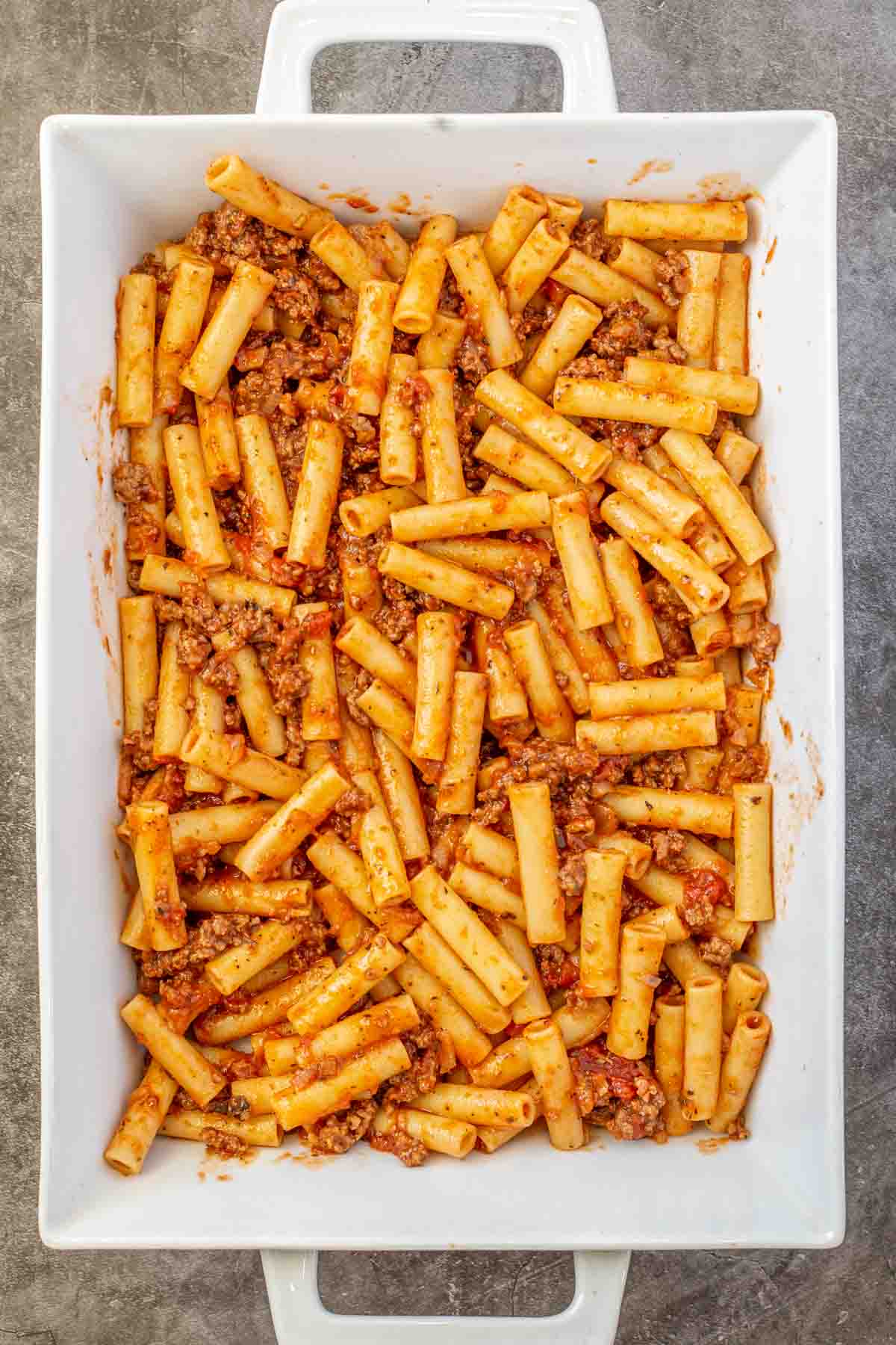The meaty pasta arranged in a casserole dish. 