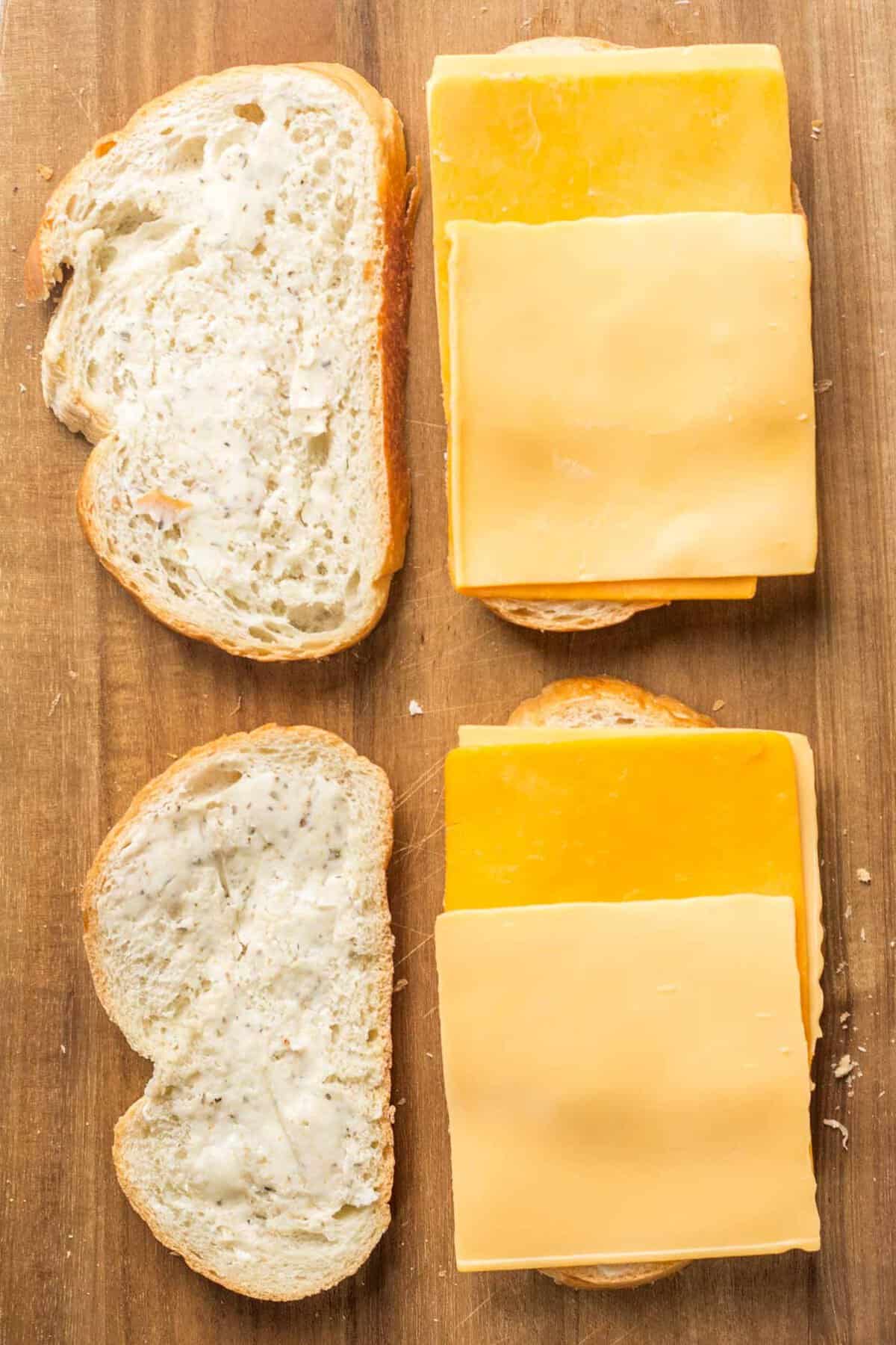 Two open sandwiches, showing one slice of bread topped with cheese. 