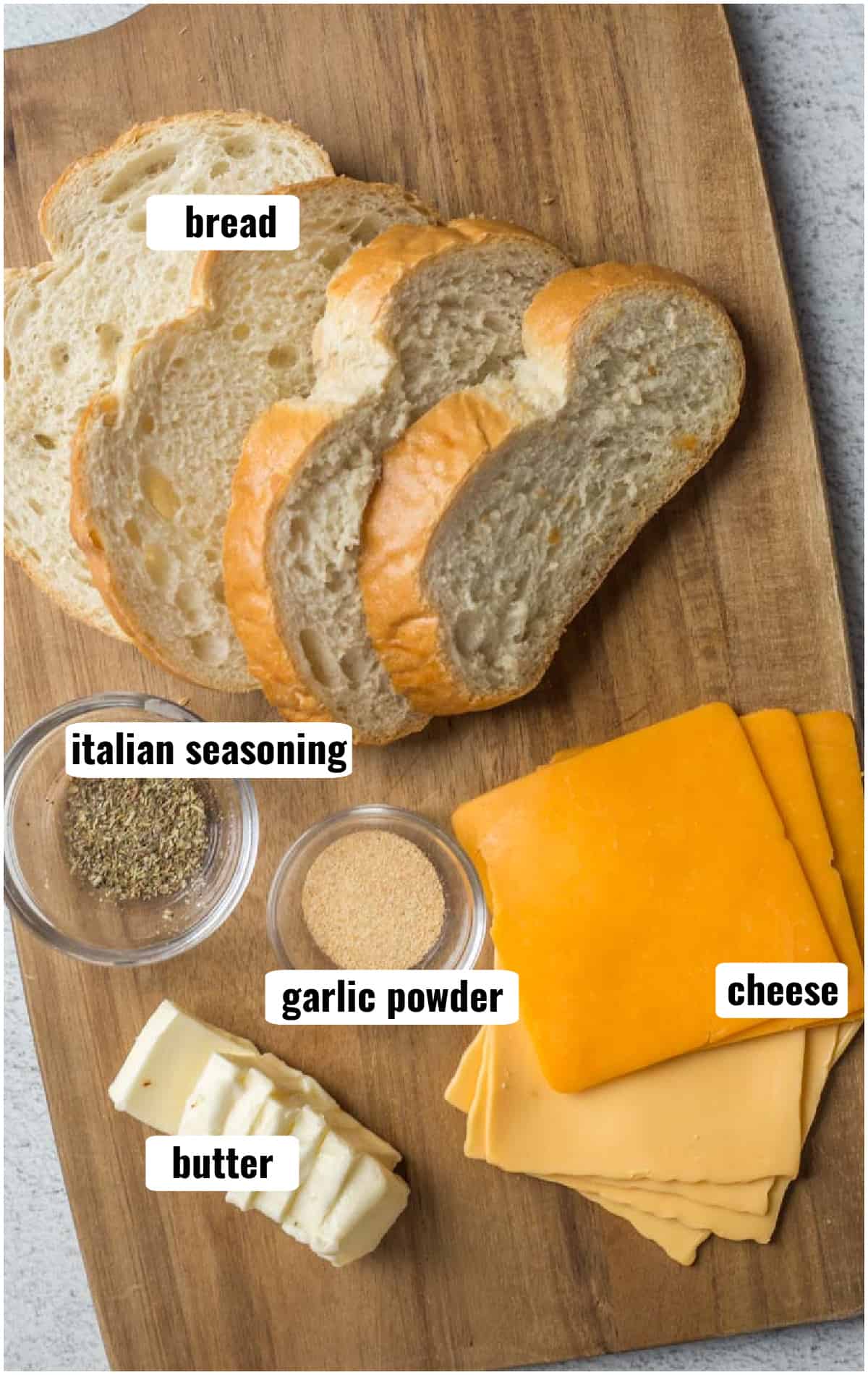 All the ingredients for making a grilled cheese, displayed on a cutting board.
