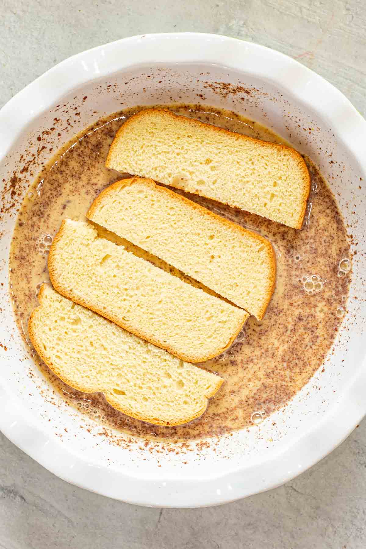 The dipped French toast sticks in a bowl. 