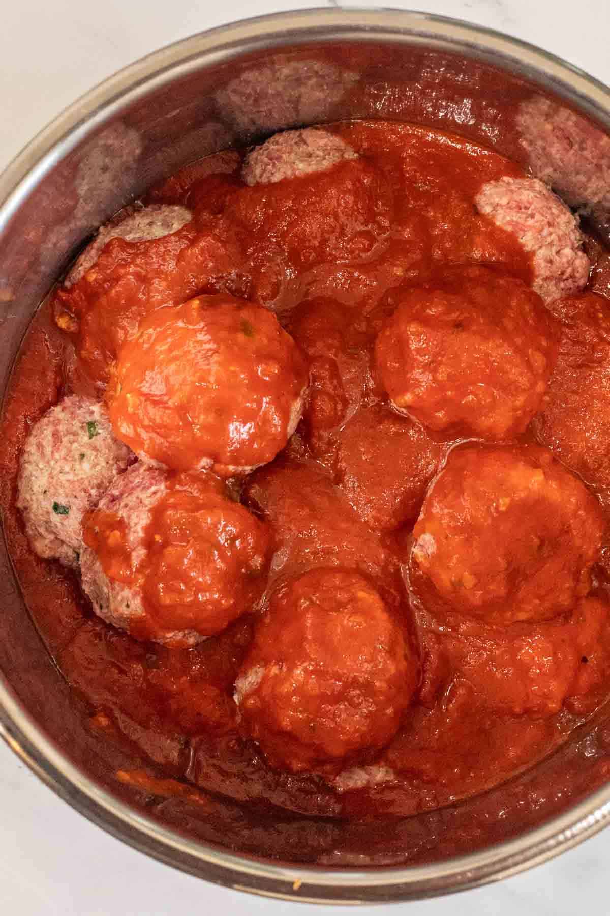 An instant pot with the cooking meatballs. 