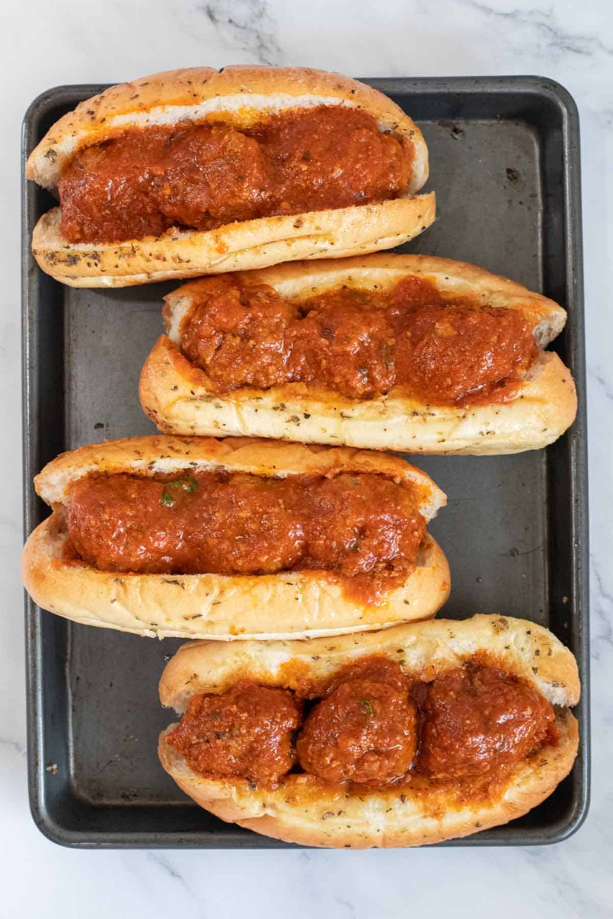 Hoagie rolls filled with meatballs. 