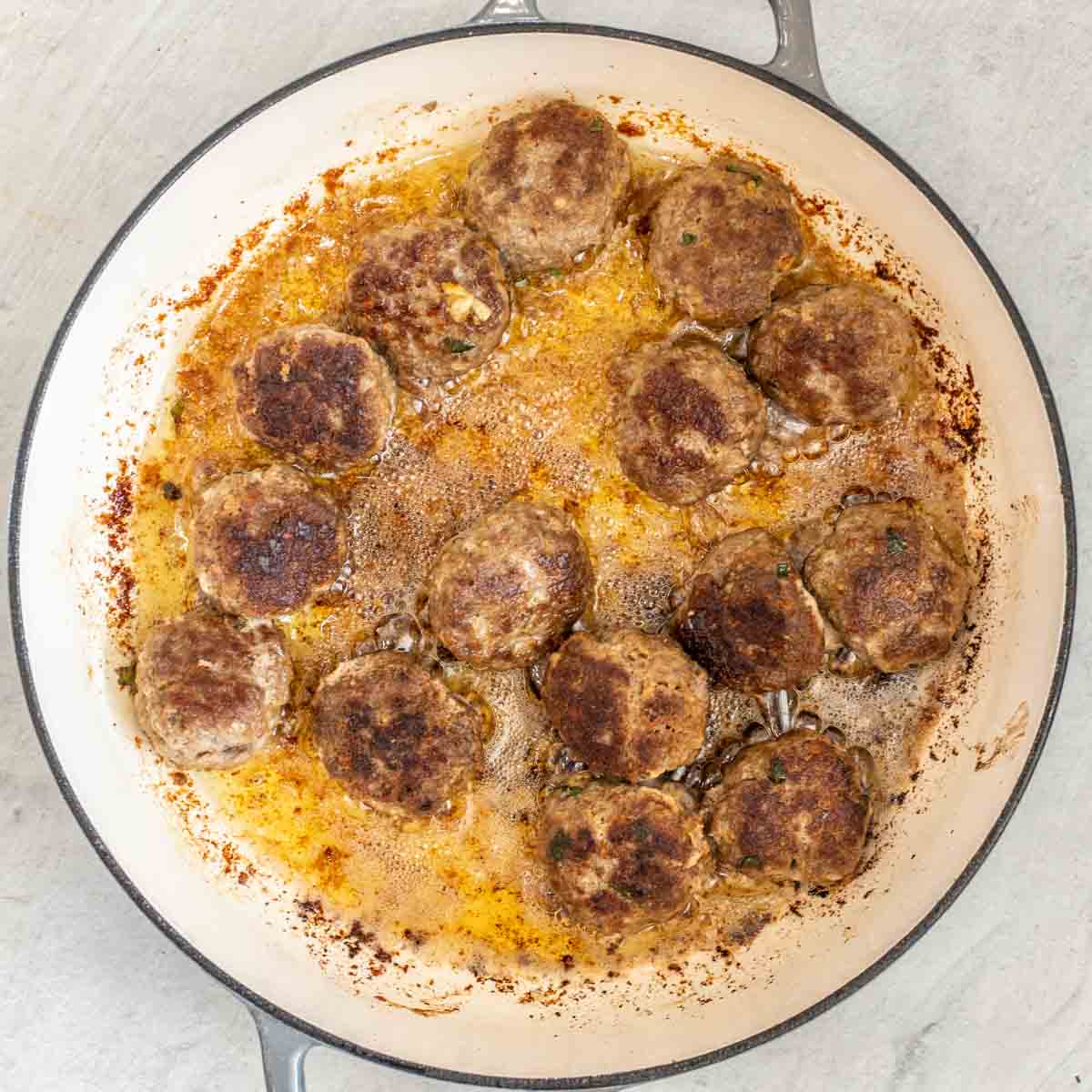 A pot with the seared meatballs. 