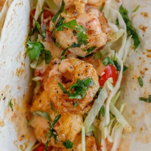 A taco with the bang bang shrimp and shredded cabbage topping.