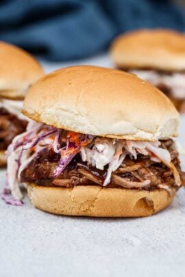 A crockpot pulled pork sandwich, topped with coleslaw.