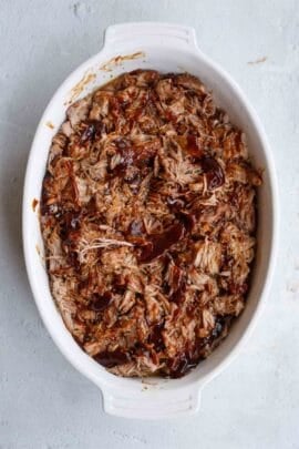 Barbecue sauce is added to the shredded pork.