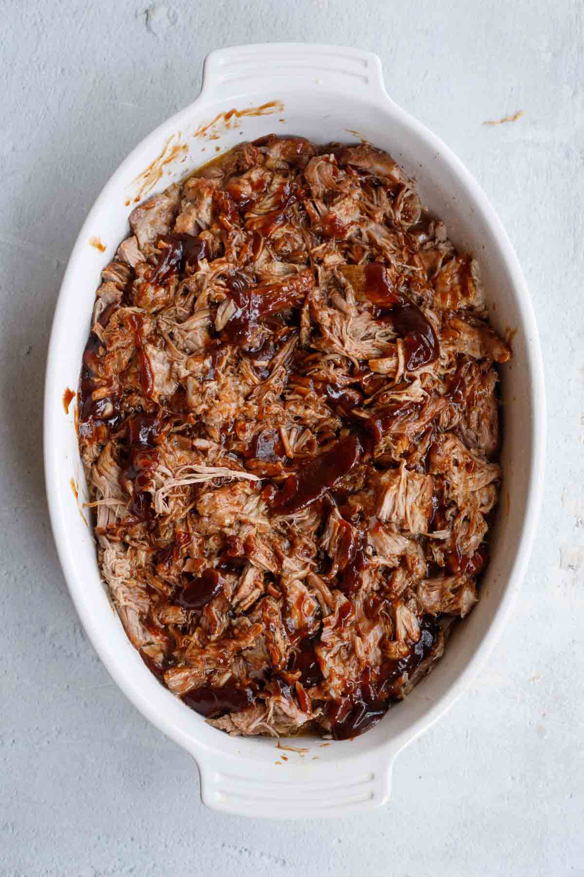 Barbecue sauce is added to the shredded pork. 