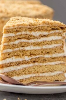 The layered honey cake slice on a white plate.