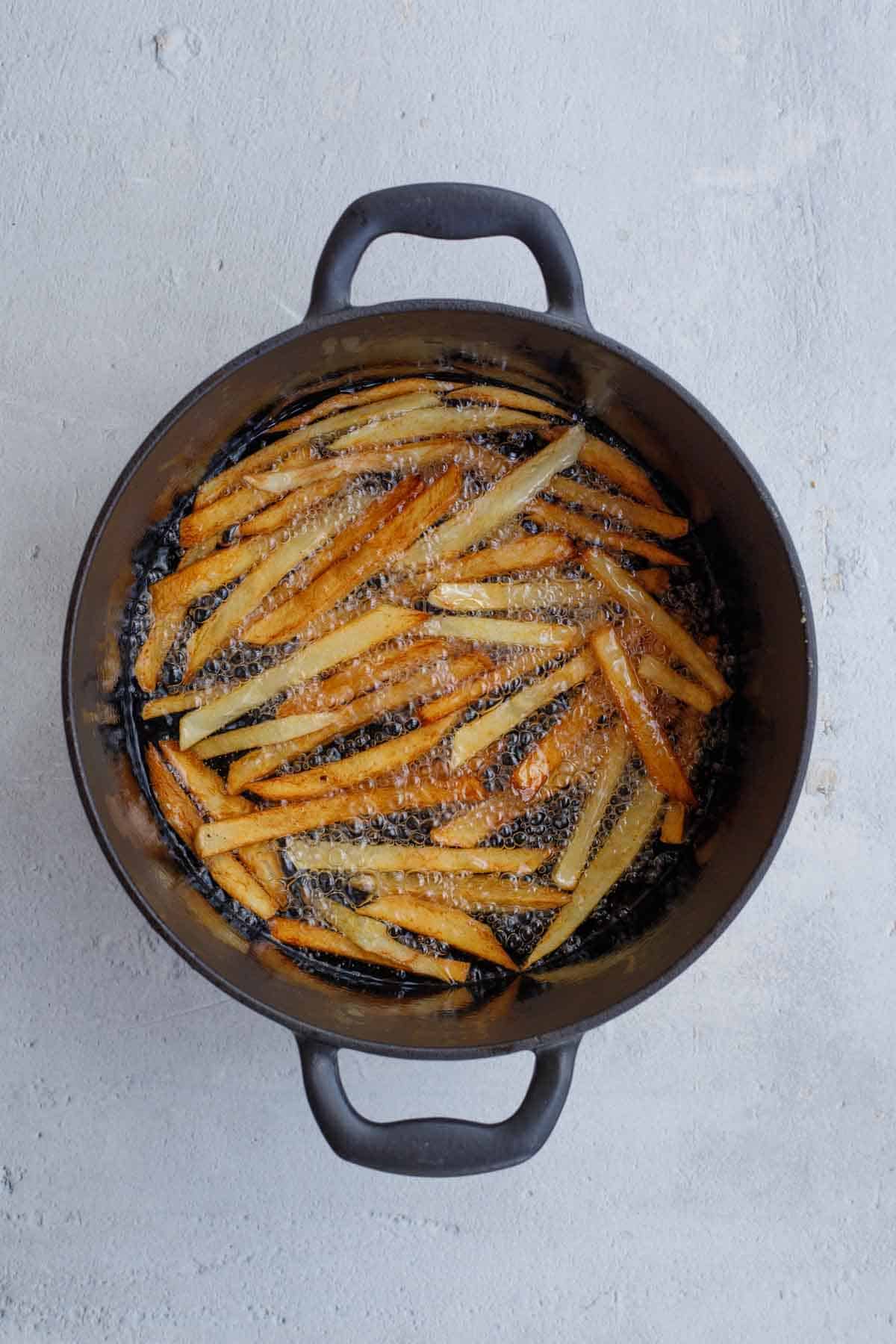 A pot with hot oil, frying the potato strands. 