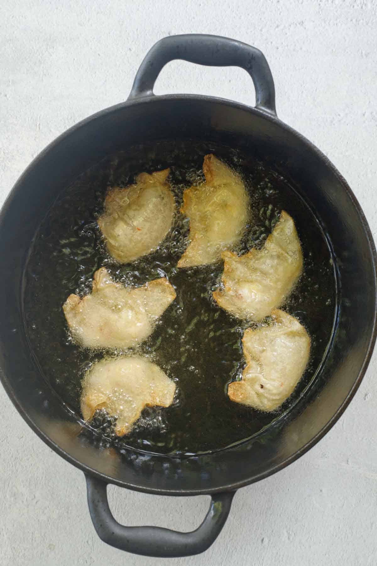 The wontons frying in the pot.