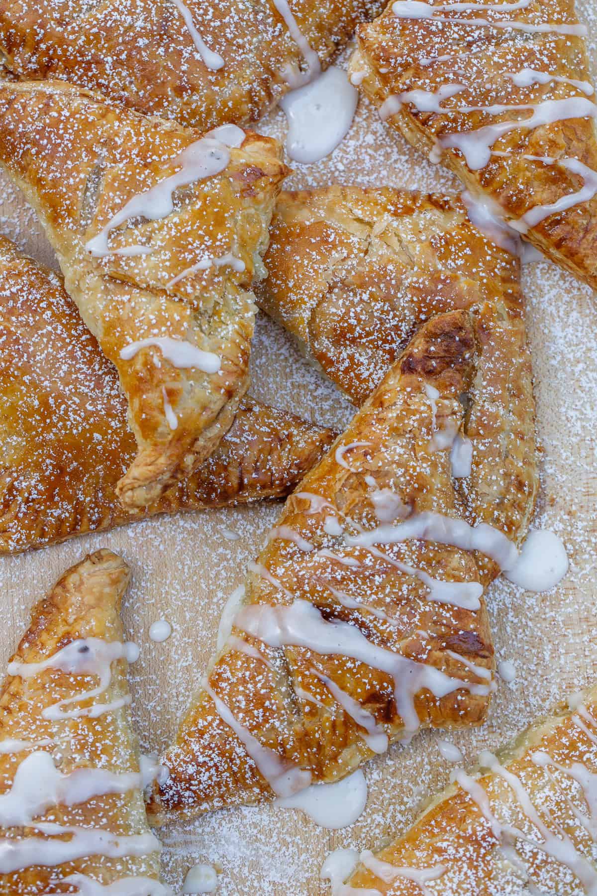 This apple turnover recipe makes the perfect pastry from scratch! The puff pastry turnover is loaded with a homemade cinnamon apple filling. The baked apple turnovers with a milky glaze.