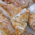 Crispy baked apple turnovers, topped with powdered sugar and a glaze.