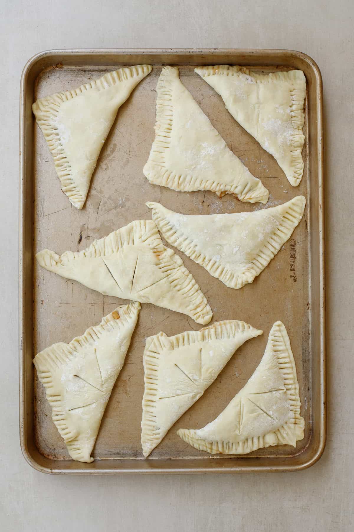 This easy apple turnover recipe makes the best pastry recipe. The folded over apple turnovers on a baking sheet.
