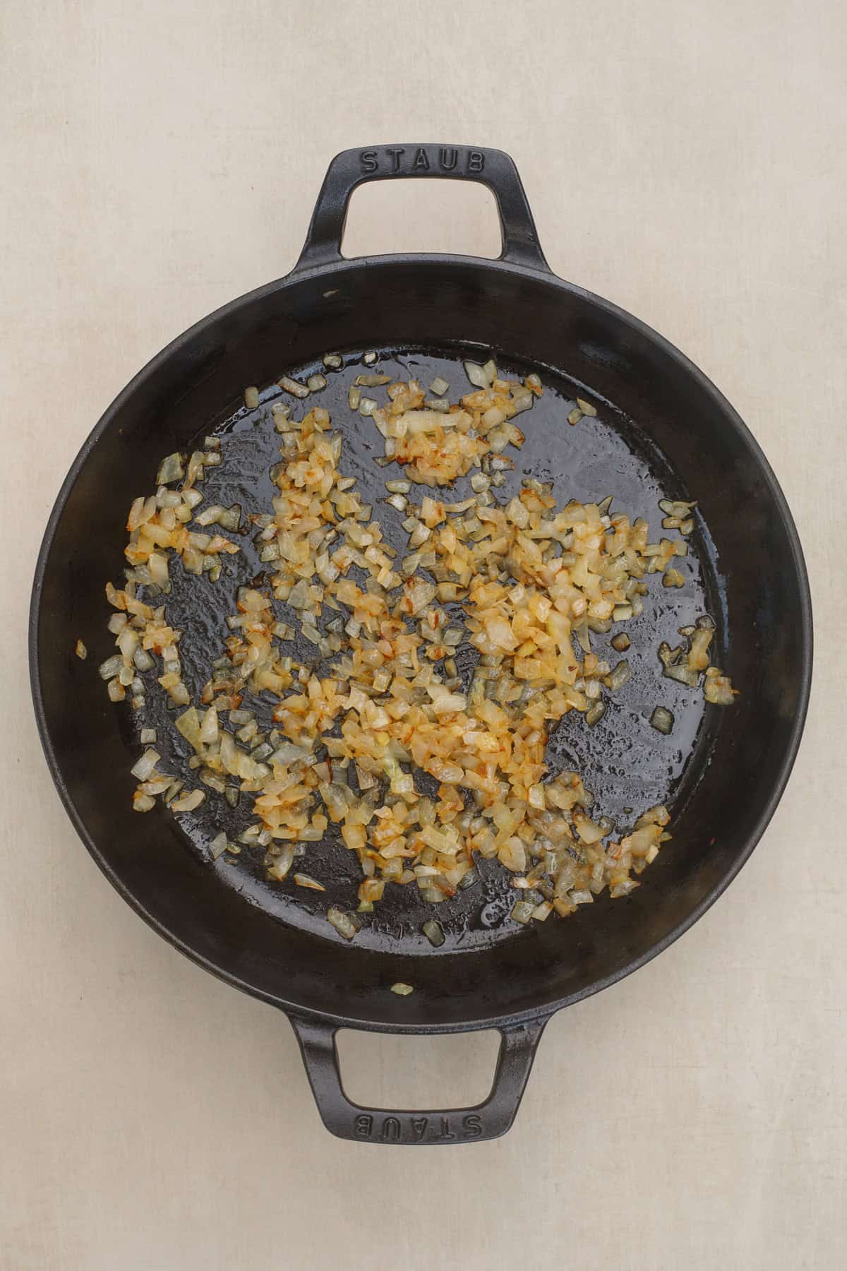 This easy chicken and rice casserole is the perfect recipe to make for a cozy fall day. A skillet with the cooking onions and garlic.