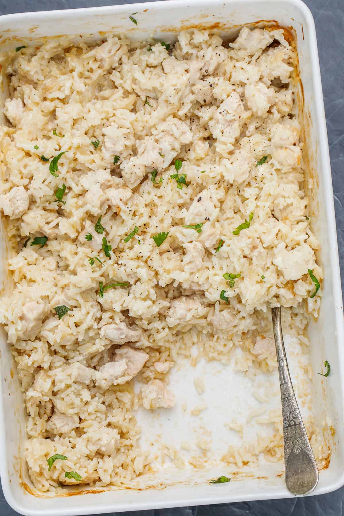 This oven baked chicken and rice casserole is a comfort meal of all comfort meals! Creamy rice, loaded with juicy chicken, and so much cheese. A dish with a spoonful of chicken and rice casserole.