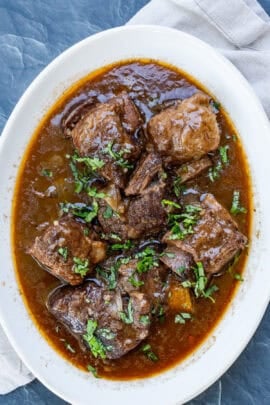 A large dish with saucey beef short ribs.