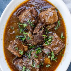 A large dish with saucey beef short ribs.