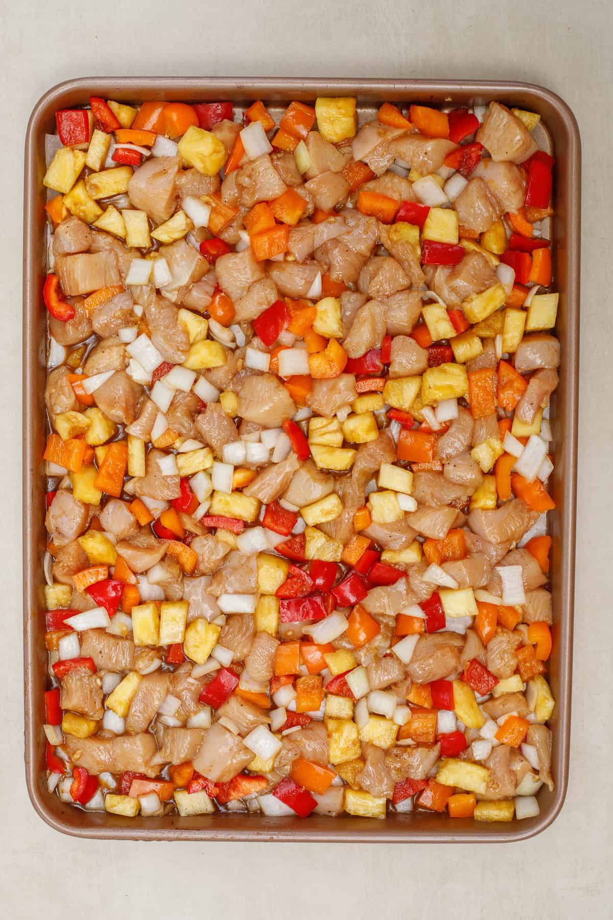 This hawaiian chicken sheet pan is loaded with juicy pineapple to make for the best well rounded meal. A sheet pan with the chicken and veggies, topped with stir fry.