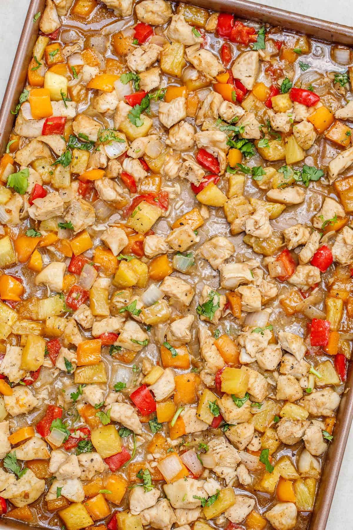 This hawaiian chicken sheet pan with pineapple makes for an easy and delicious meal that is so healthy. A baking sheet with the juicy chicken and vegetables in a hawaiian stir fry sauce.