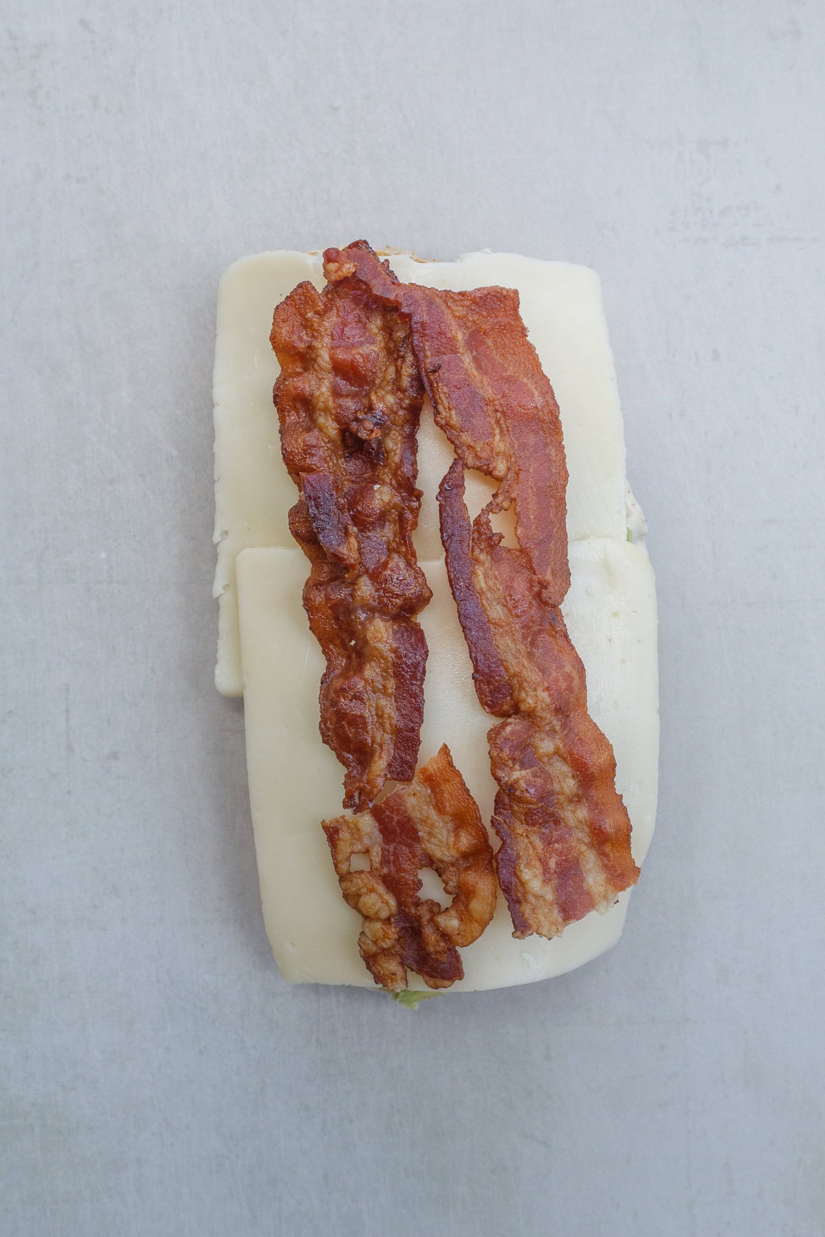 This quick and easy turkey sandwich recipe is the perfect 15 minute lunch. Layers of cheese and bacon on the sandwich bread.