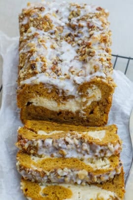 A loaf of pumpkin bread with a layer of cheesecake filling in the middle.