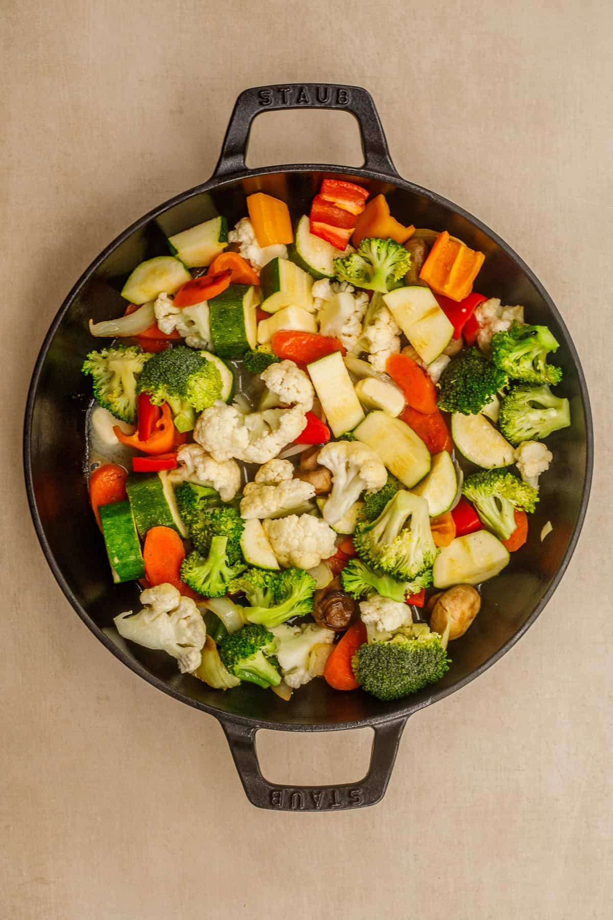 These thai chili sauteed veggie recipe makes the perfect side dish. A cast iron with chopped veggies.