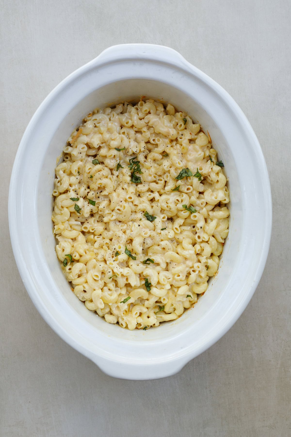 This slow cooker mac and cheese is the perfect thanksgiving side dish that cooks in just the slow cooker. The process is super easy, and can be kept warm for hours! A crockpot with the slow cooker mac and cheese.