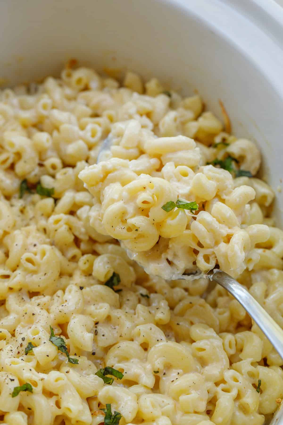 This crock pot mac and cheese recipe makes the perfect comfort meal in the slow cooker. A spoonful of the cheesy mac and cheese that cooks in the crockpot.