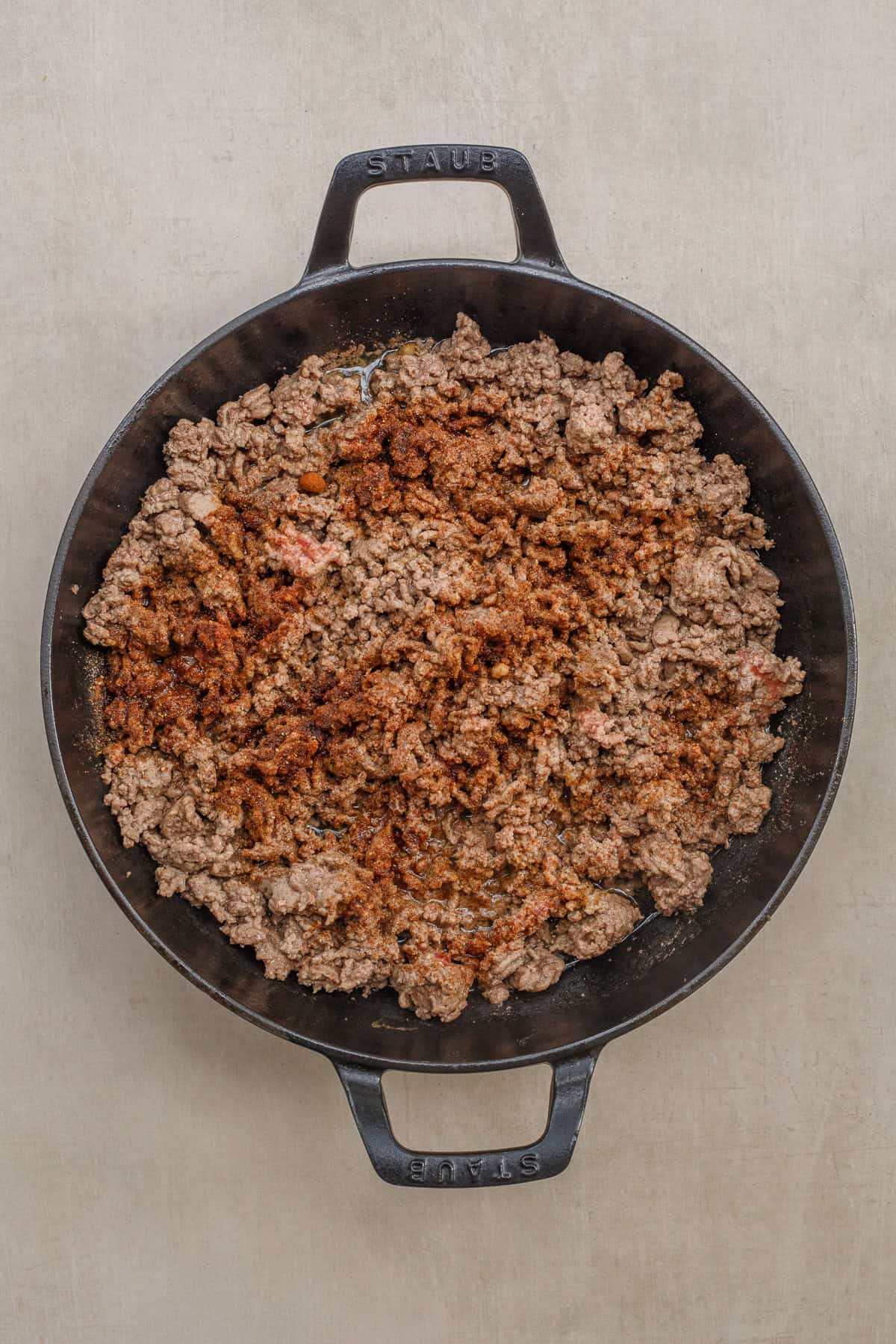 This slow cooker chili is loaded with tender beef, a variety of veggies, and the best toppings. A pan with the ground beef cooking in a pan.