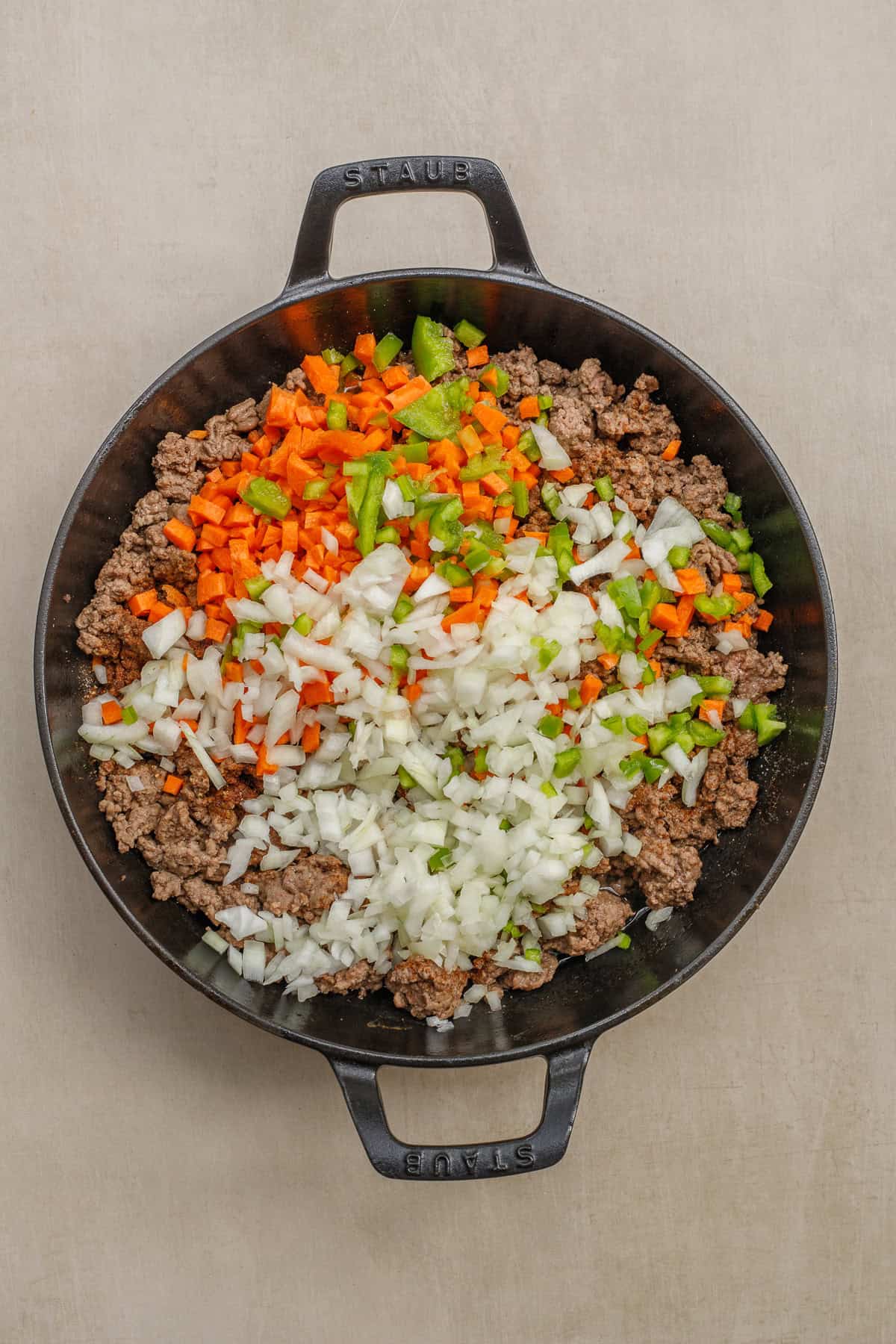 A crockpot chili is made extra delicious with a variety of toppings. A pan with the cooked meat and diced vegetables.