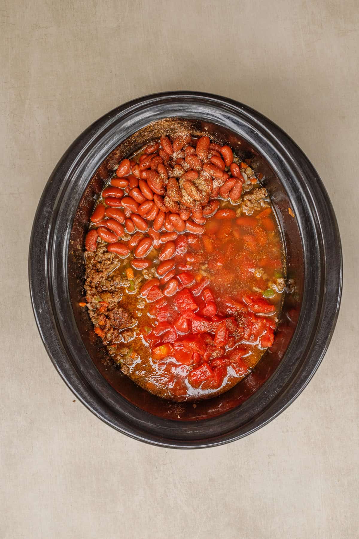 This ground beef crockpot chili makes the perfect comfort meal from scratch. A crockpot with the meat and veggie mix, and every other chili ingredient.