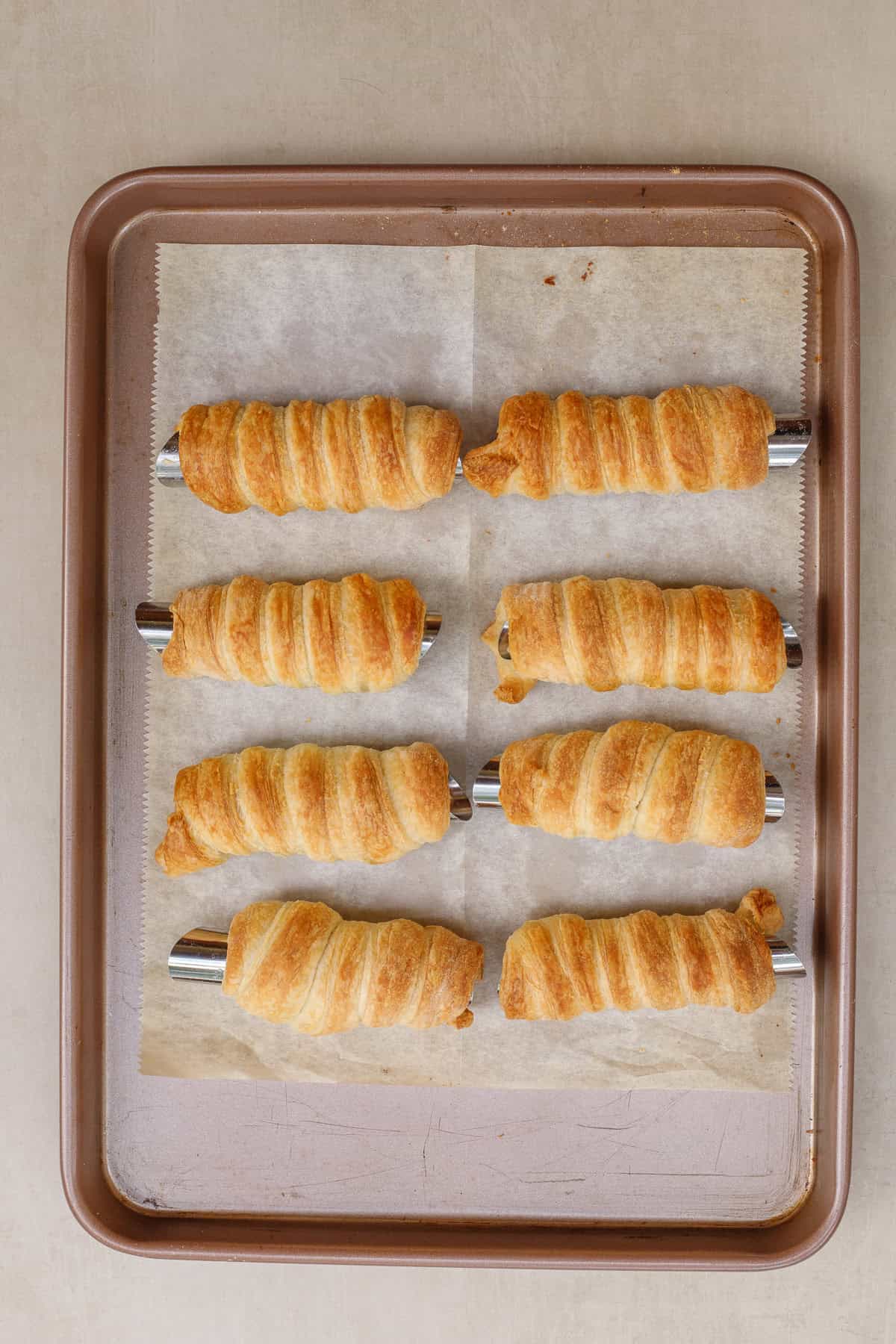 A baking sheet with the baked puff pastry horns.